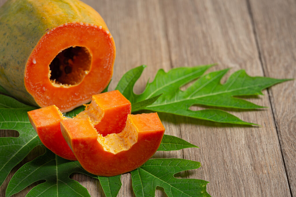 fresh papaya, cut into pieces, put on a wooden floor