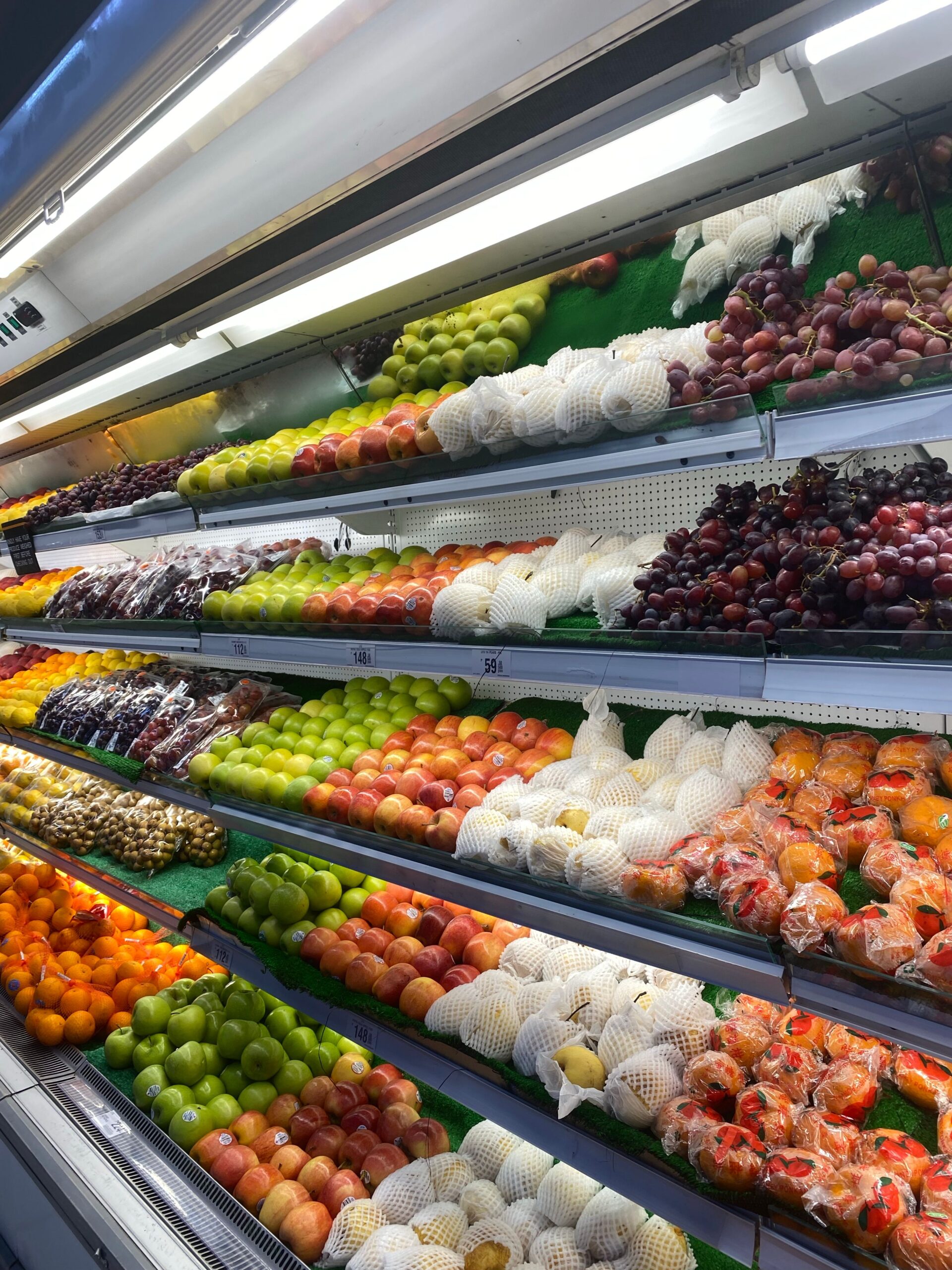 Vibrant assortment of fresh fruits neatly arranged in a grocery store display.